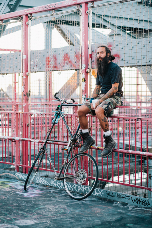 rides a custom tall bike photographed on the Williamsburg Bridge going home from work