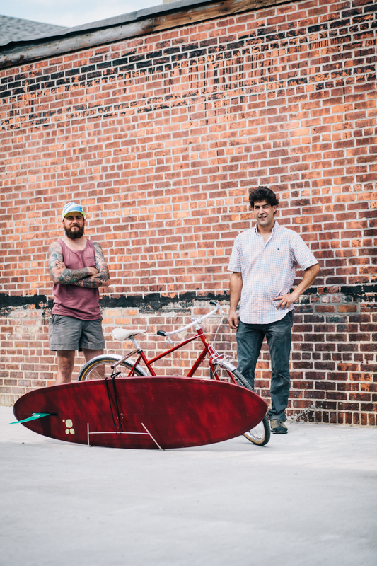 Benjamin and Eric with the Benjamin Cycles "Johnny Utah" bike in "Ohio State Red" with the Racer Racks "Bodhi" surfboard rack  photographed at the Knockdown Center in Maspeth, Queens  while exhibiting at the Bike Cult Hand-Built Bike Show