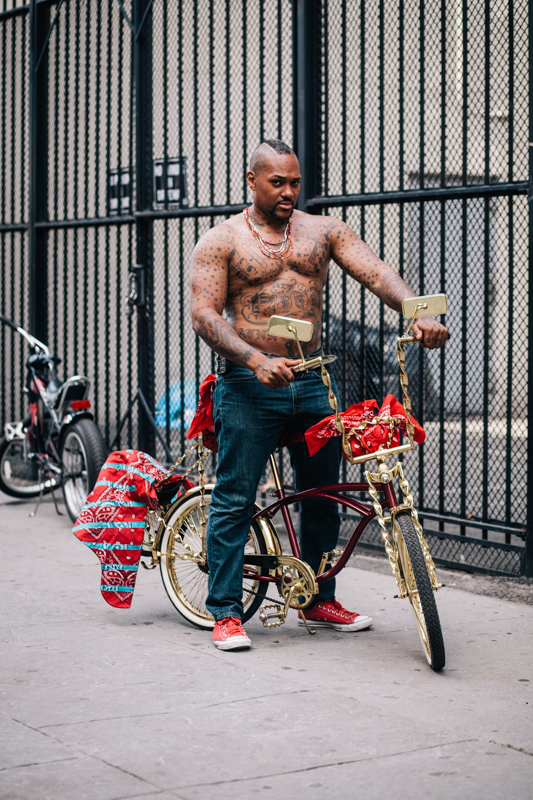 rides a Kenda low-rider red & gold twisted frame photographed at St. Felix St. and Lafayette Ave., Brooklyn  at the Dance Africa Street Festival